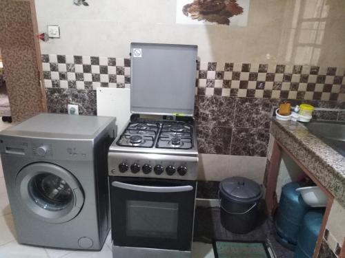 伊夫兰Chalet de la montagne的厨房配有炉灶和洗衣机。
