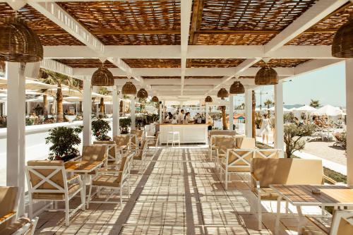 都拉斯帕拉斯温泉酒店的海滩上带桌椅的餐厅