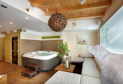 葱仁谷Hotel 3 Vallées Val Thorens的一间带浴缸和沙发的客厅