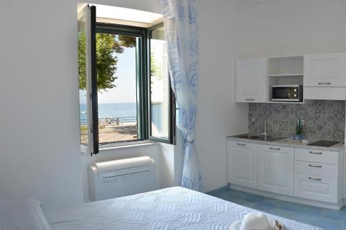 马奥莱Una Finestra sul Mare的厨房配有1张床和海景窗户。