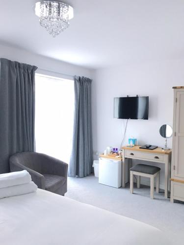 索尔兹伯里Prestbury Bed & Breakfast的一间卧室配有一张床、一把椅子和一张书桌