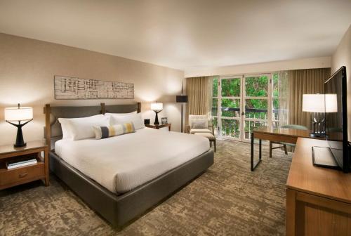 坦培Tempe Mission Palms, a Destination by Hyatt Hotel的酒店客房配有一张床、一张书桌和一台电视。