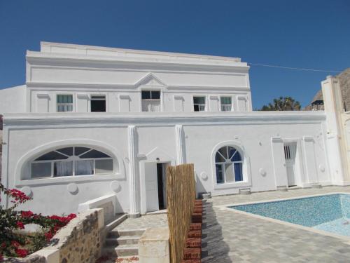 安坡里奥圣托里尼Loukas Kontos Traditional House的一座白色的房子,前面设有一个游泳池