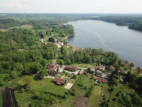 TumianyFolwark Tumiany Pokoje & Restauracja的享有湖畔房屋的空中景致