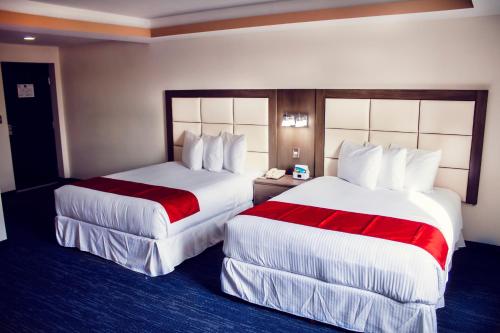 托雷翁Hotel ALO! Express的酒店客房带两张红色和白色的床单