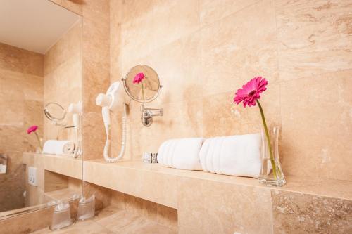 比斯特里察Grand Hotel Coroana的浴室设有水槽和花瓶