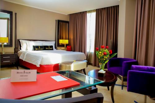 巴厘巴板巴厘巴板苏黎酒店的酒店客房带一张床、一张桌子和椅子