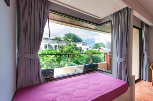 卡伦海滩Karon Sea Sands Resort-SHA PLUS的卧室设有粉红色的床和大窗户