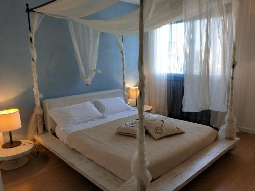 利多迪耶索罗Heron apartments的一间卧室配有一张带天蓬的白色床