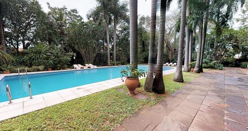 亚松森德尔巴拉圭格兰酒店的一座游泳池,旁边是种盆栽植物