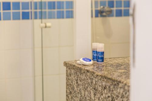 瓜拉图巴Spazio Marine Hotel - Guaratuba的带淋浴和一瓶牙膏的浴室台面