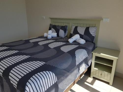 韦斯特布鲁克Westbrook Cabanas 2nd的一间卧室配有一张蓝色和白色的床,设有床头柜