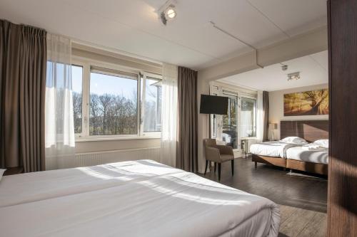 Ellecom兰德格德艾维格弗莱彻酒店的酒店客房设有床和窗户。
