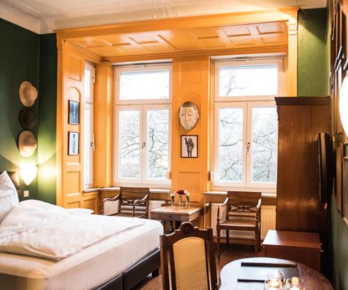 慕尼黑Hotel Ritzi的卧室配有床、桌子和窗户。