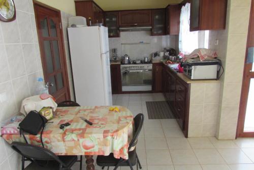埃斯帕戈斯Rooming house的厨房配有桌子和白色冰箱。