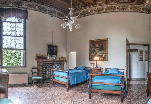 蒂耶内Castello di Thiene的客房设有两张床和吊灯。