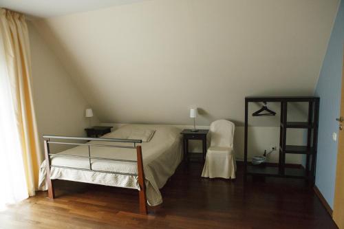 特拉凯Entire house in Trakai的卧室配有1张床、1张桌子和1把椅子