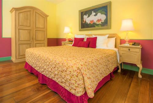 图里亚尔瓦Hotel Casa Turire的一间卧室配有一张带红色枕头的大床