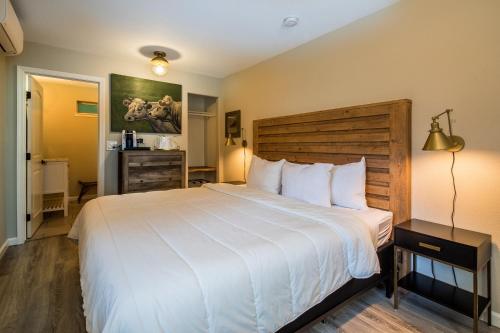 盖尔南维尔沿河路别墅酒店的卧室配有一张白色大床和木制床头板