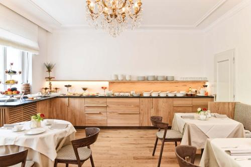 拉古多Ansitz Punthof的一间带2张桌子和吊灯的用餐室