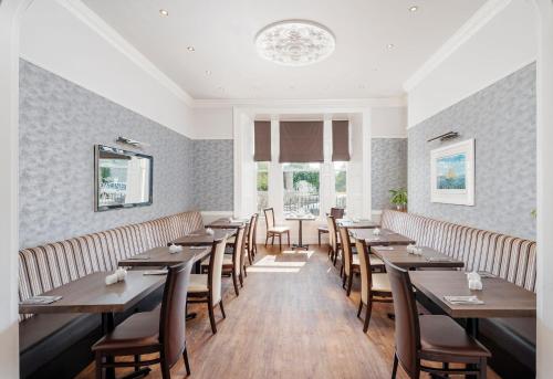普里茅斯因维克塔酒店的用餐室配有木桌和椅子