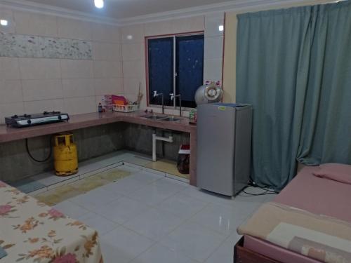 拉瑙Homestay pekan ranau的一间带水槽和冰箱的厨房