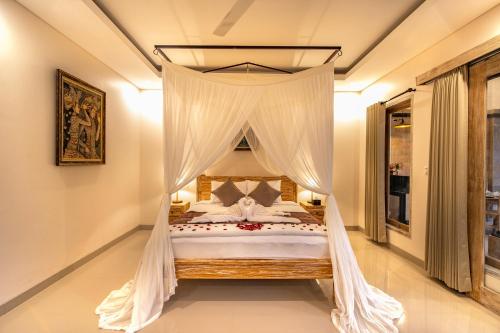 乌布Puri Sedana Ubud Villa的卧室配有带白色窗帘的天蓬床