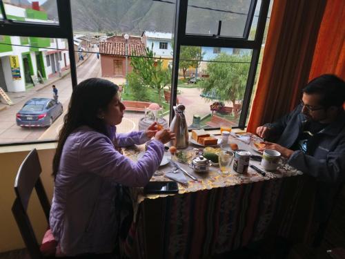 San PedroHostal Inca的坐在餐桌旁吃食物的男人和女人