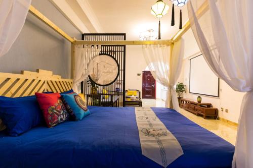 西宁【路客】西宁市城西区·万达广场·路客精品公寓·00151720的一间卧室配有一张带窗帘的大型蓝色床