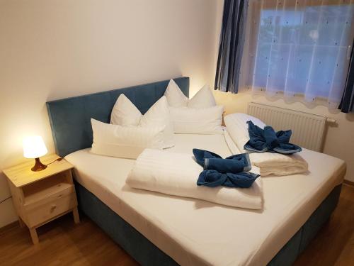 施图拜河谷新施蒂夫特Ferienwohnung Dominik的一张带白色枕头和蓝色弓的床铺