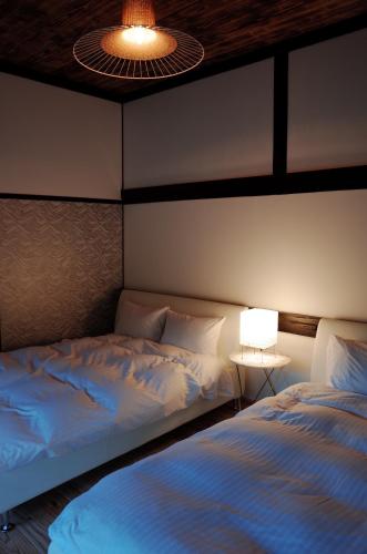 五岛Okune的一间卧室配有两张床、一盏灯和一盏灯。