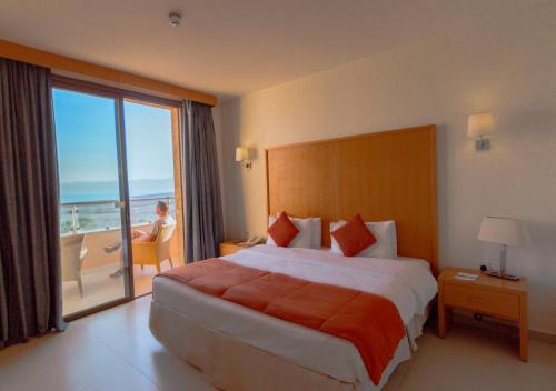 索瓦马死海华美达度假酒店的酒店客房设有一张床,享有海景。