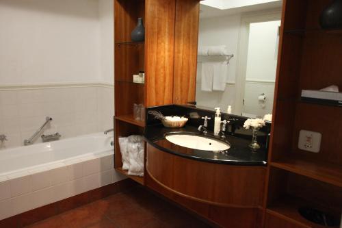 Kuilsrivier赛文瓦赫特乡村旅馆的浴室配有盥洗盆和浴缸。