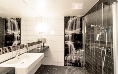 米尔克河谷Myrkdalen Resort Hotel的黑白浴室设有水槽和淋浴