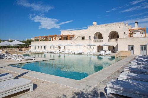 萨维勒特里博尔戈艾格纳齐亚酒店的一座带椅子的游泳池以及一座建筑