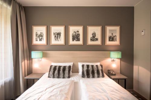 米尔克河谷Myrkdalen Resort Hotel的卧室配有一张墙上三幅照片的床