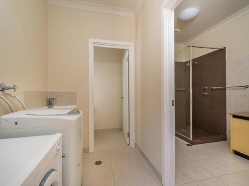 朱里恩湾Seafront Unit 60的白色的浴室设有水槽和淋浴。