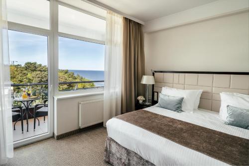 尤尔马拉波罗的海海滩酒店及SPA的酒店客房设有一张床和一个阳台。
