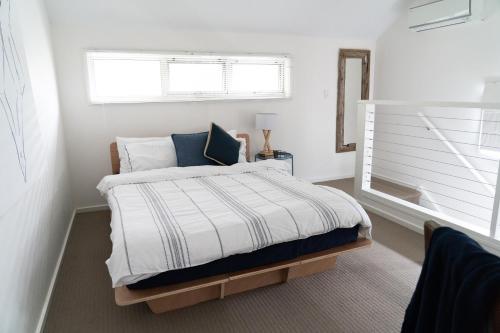 高勒Gawler Townhouse 1 Bedroom的白色卧室设有一张带窗户的床