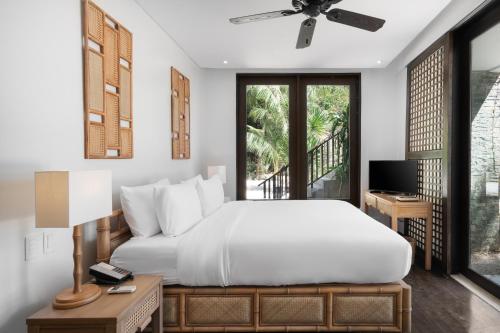 爱妮岛米尼洛岛爱妮岛度假酒店的卧室配有白色的床和电视。