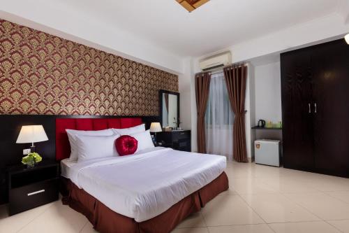 河内Hanoi Amore Hotel & Travel的一间卧室配有一张红色枕头的床