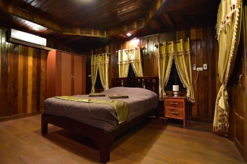 罗勇Linda's Place的卧室配有一张床铺,位于带木墙的房间内
