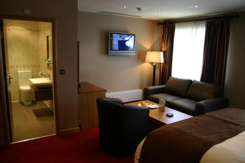 BeamishBeamish Park Hotel的酒店客房配有床、沙发和桌子。