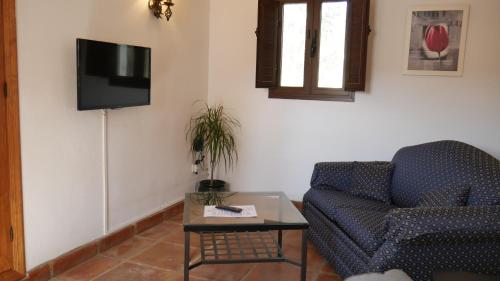 隆达La Perla Blanca - Ronda的客厅配有沙发和墙上的电视