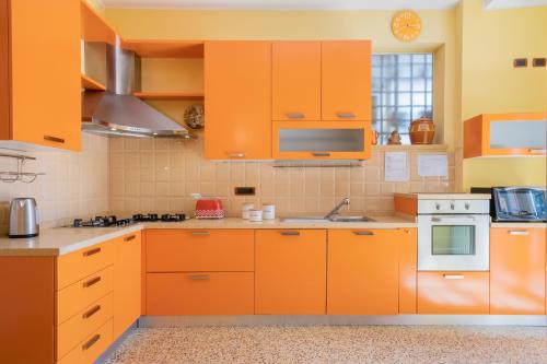 博洛尼亚Petroni 38 by Studio Vita的橙色的厨房配有白色家电和橙色橱柜