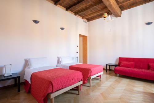 博洛尼亚Petroni 38 by Studio Vita的一间卧室配有两张床和一张红色沙发