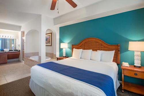 奥兰多迪士尼附近的布埃纳维斯塔湖度假村及水疗中心的一间卧室设有一张大床和蓝色的墙壁