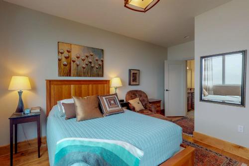 桑德波因特Seasons at Sandpoint的卧室配有床、椅子和窗户。