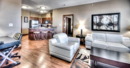 大草原城Grand Inn & Residence- Grande Prairie的一间带两把椅子的客厅和一间厨房