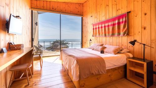 伊科Hotel Puerto Viejo Llico的一间卧室配有一张床、一张书桌和一个窗户。